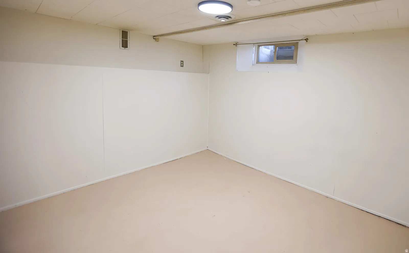 Spacious room with light-toned flooring and white paneling