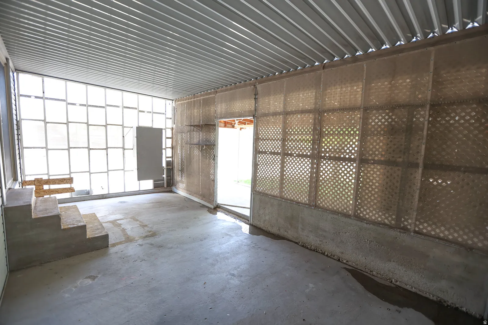 Open-concept space featuring a corrugated metal ceiling and concrete flooring