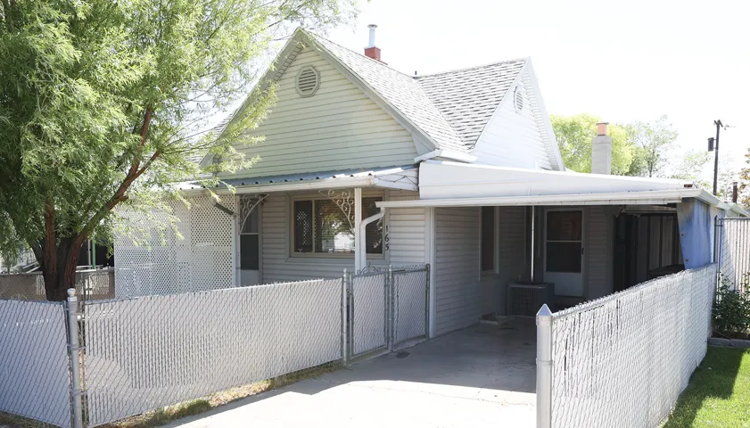Home exterior featuring light-colored siding, a gabled roofline, and a prominent covered carport