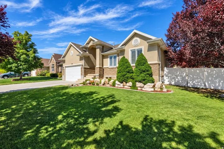 Stucco exterior with brick accents, prominent front gables, and an attached garage