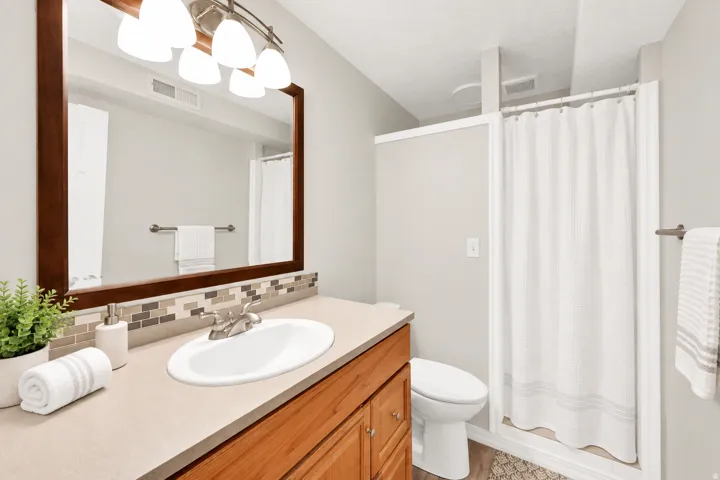 Wood-finish vanity with an integrated sink and brushed nickel faucet