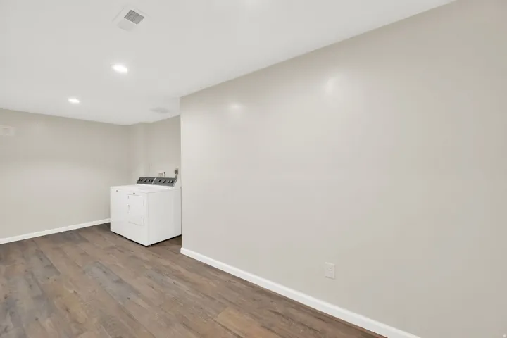 Laundry area featuring wood-finish flooring, recessed lighting, and neutral wall paint