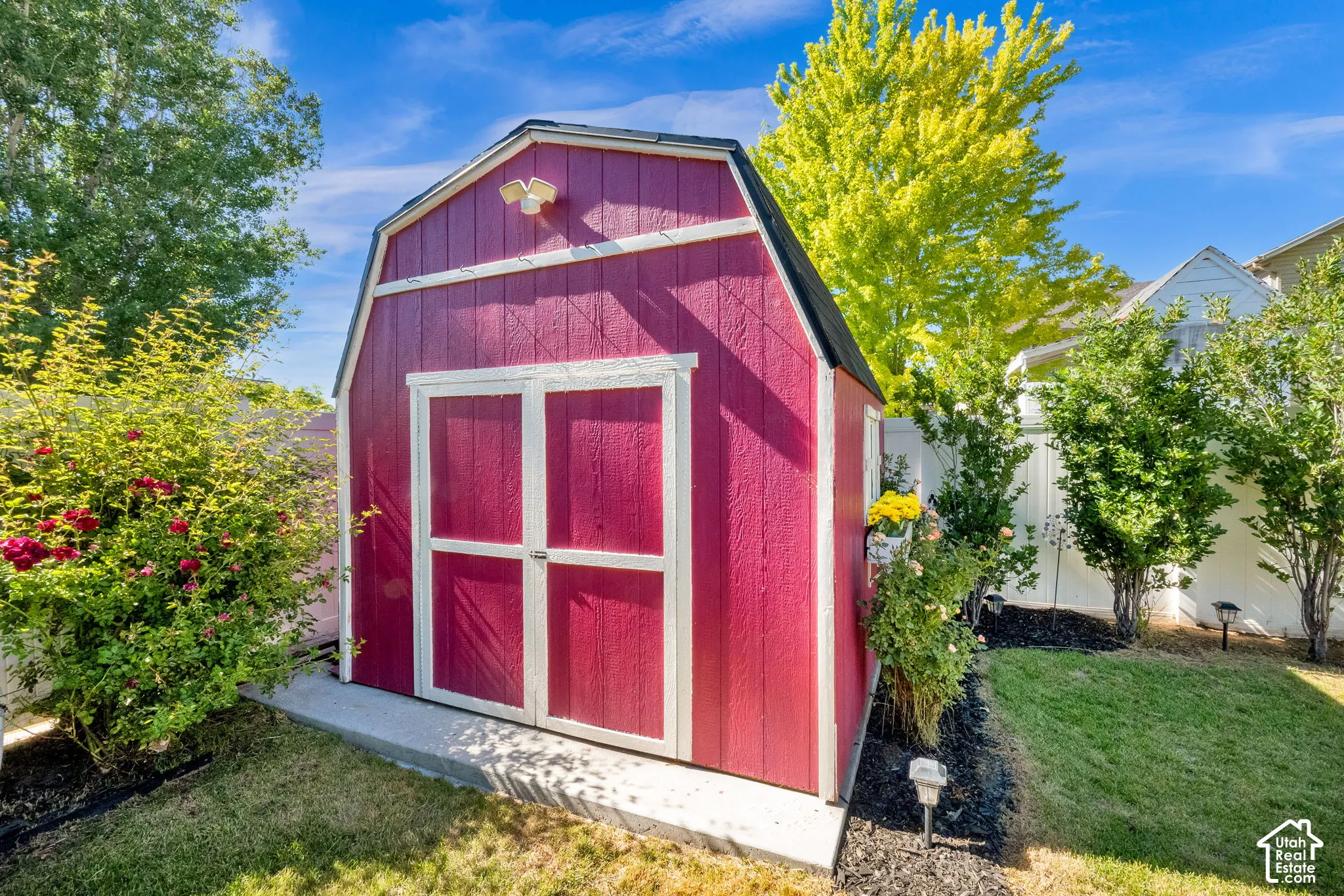 Red barn-style shed with white trim and double doors