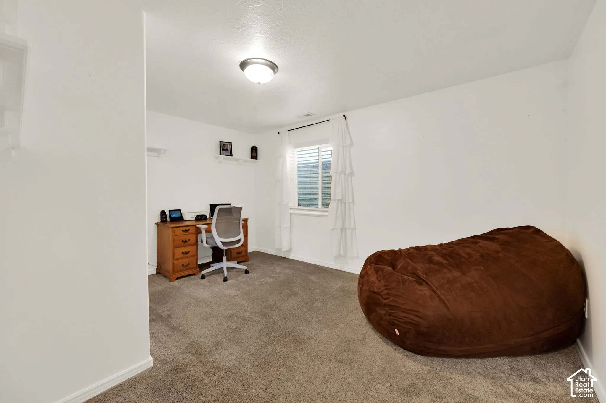 Versatile interior room featuring neutral carpeting and white wall finishes