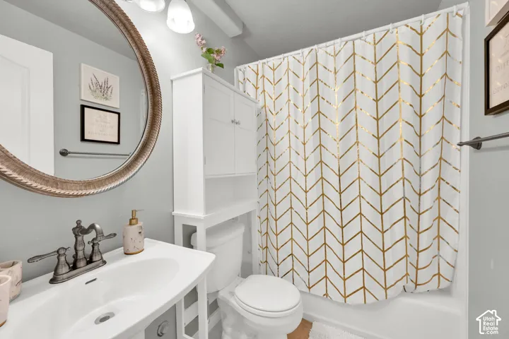 Bathroom featuring a white vanity with integrated sink, bronze-finish faucet, and a large round mirror