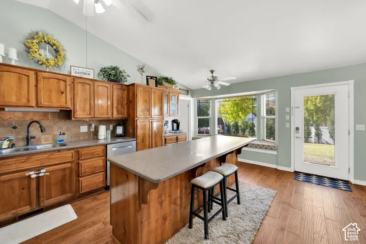 Kitchen featuring wood cabinetry, stone-look countertops, and an integrated island with breakfast bar seating