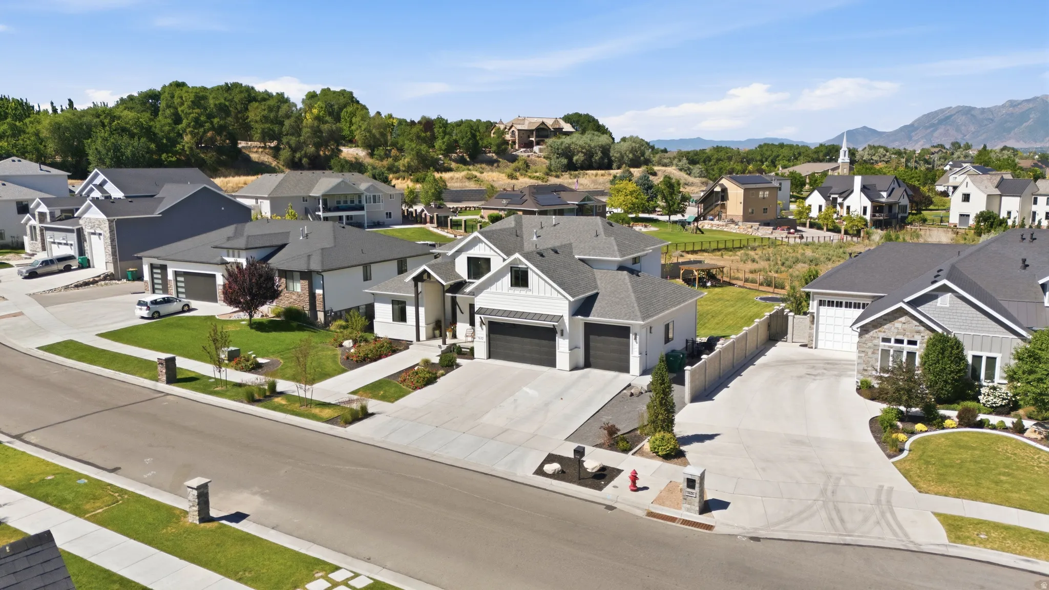 Contemporary two-story residence with a gray shingle roof, white siding, and dark garage doors