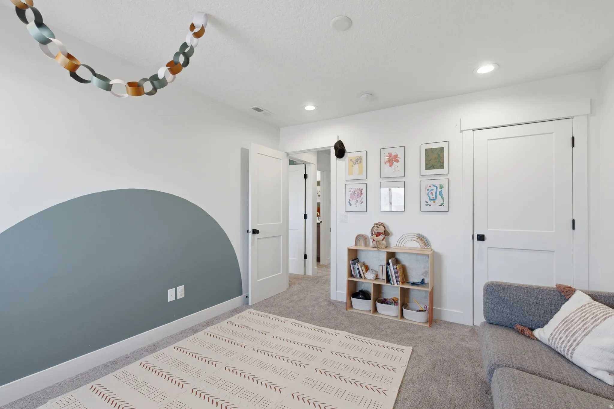 Carpeted room featuring a decorative accent wall, white trim, recessed lighting, and white paneled doors