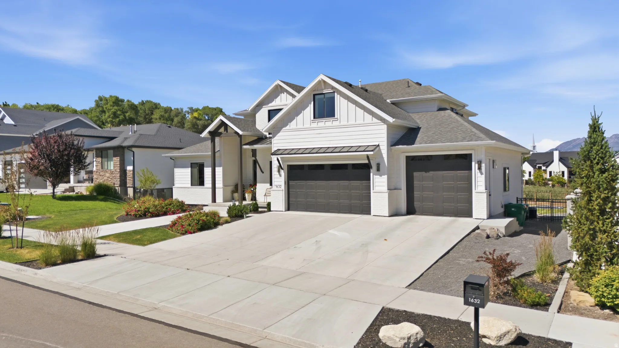 Modern farmhouse-style exterior featuring white siding and dark trim