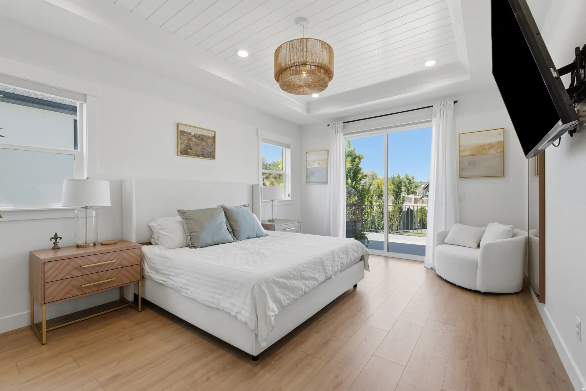 Recessed lighting and a decorative chandelier illuminate the coffered ceiling with shiplap detail