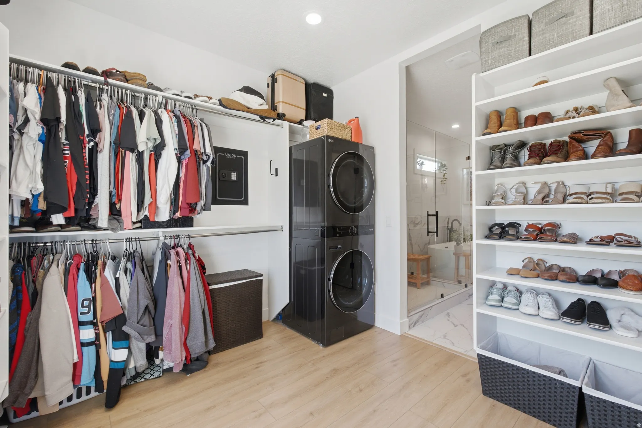 Integrated laundry area featuring stacked black washer and dryer units