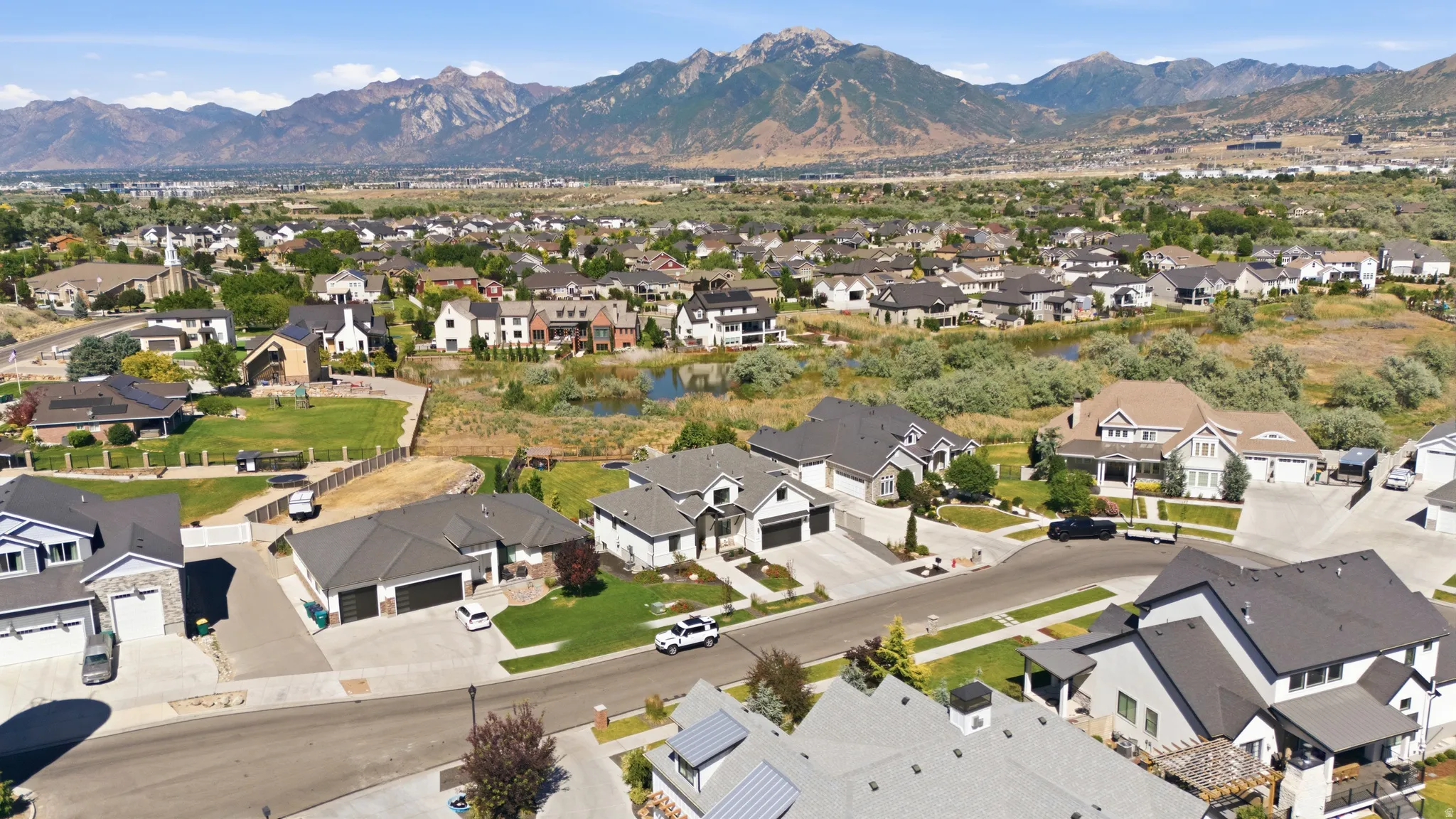 Expansive neighborhood with diverse architectural styles, mature landscaping, and mountain backdrop