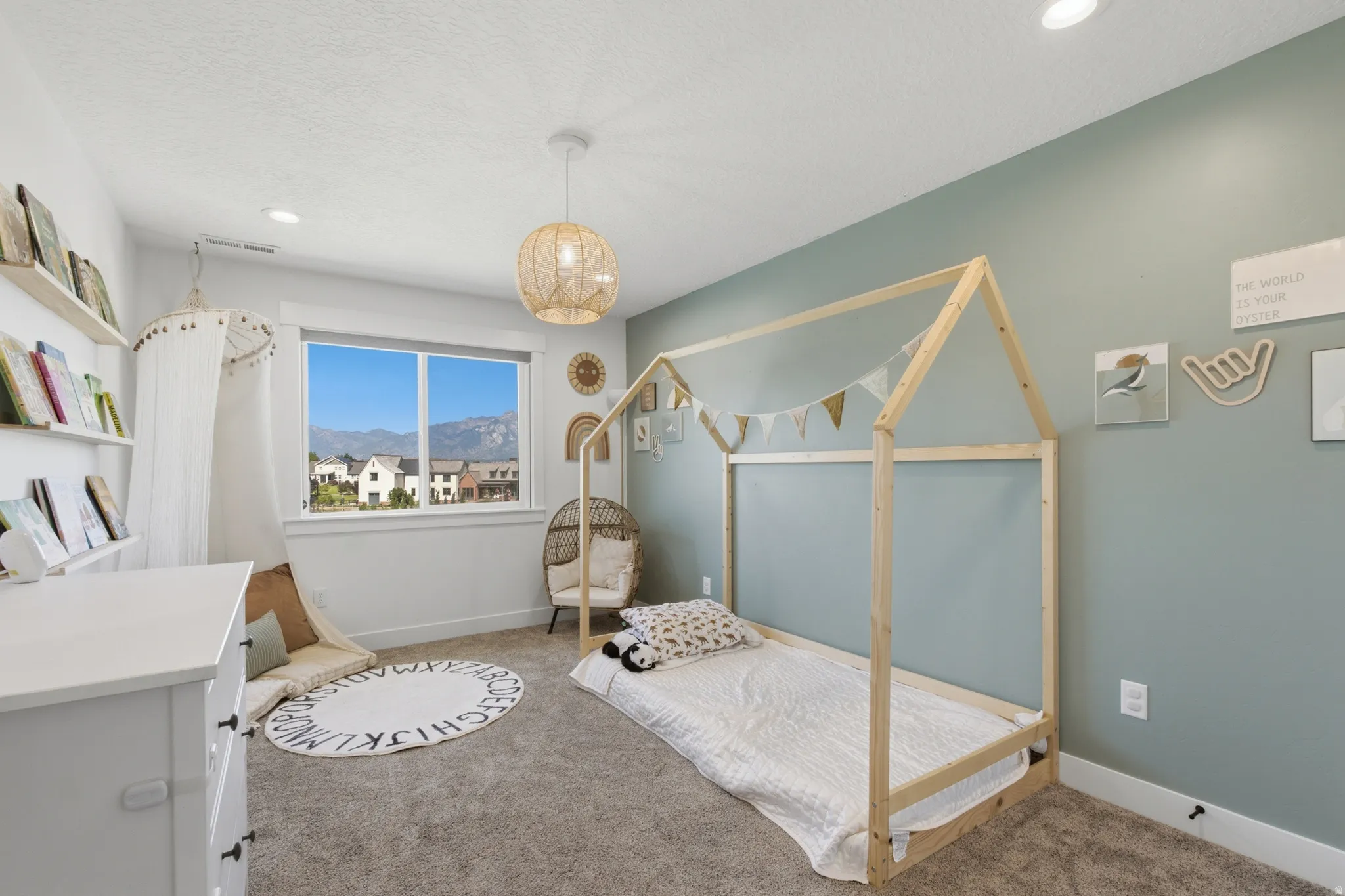 Room featuring a large window, carpeted flooring, and a pastel accent wall