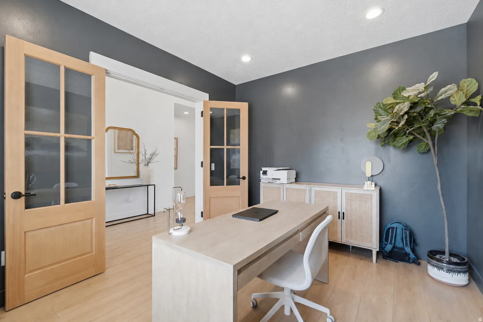 Room featuring light wood-finish flooring, recessed lighting, and a dark accent wall