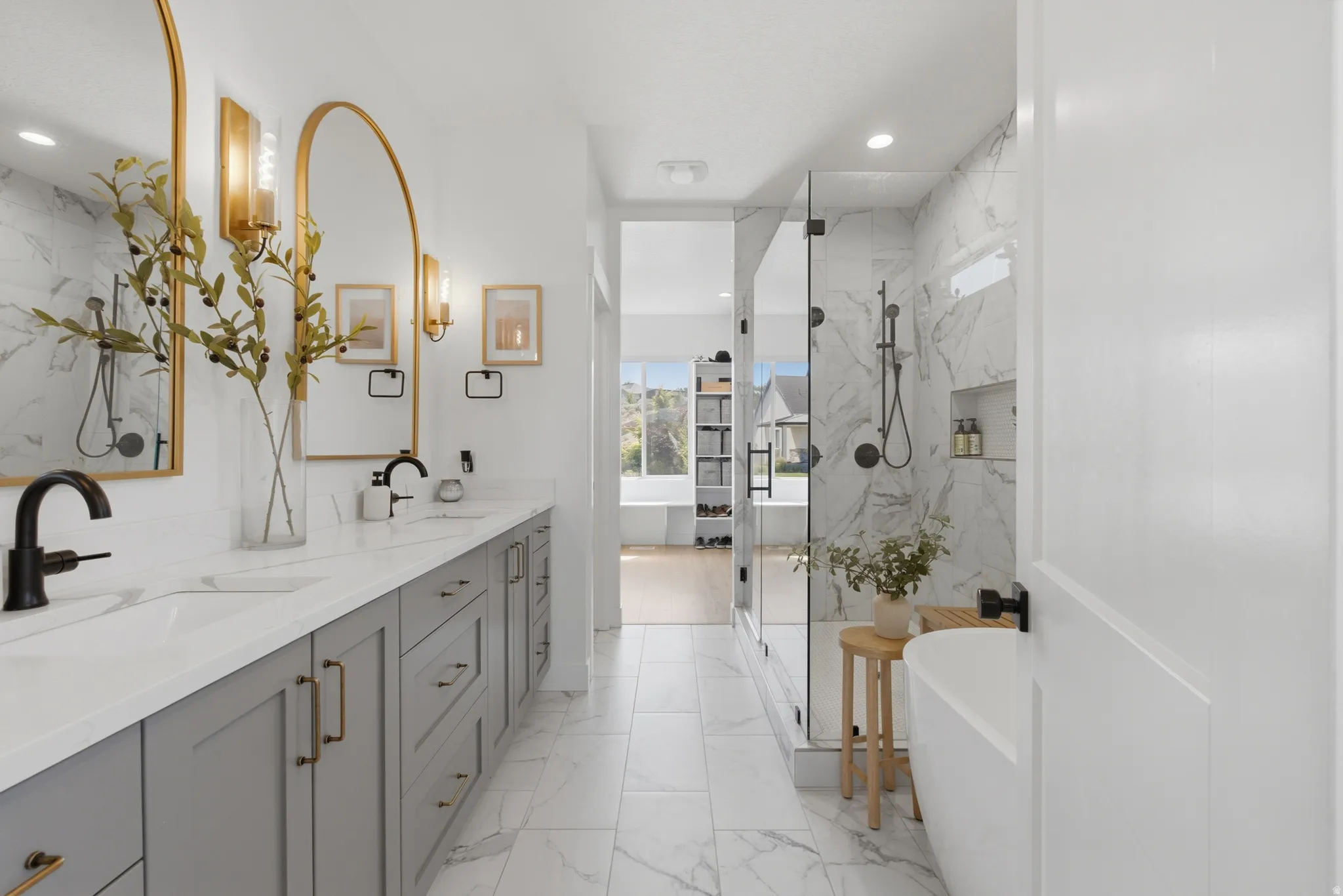 Contemporary bathroom featuring a long double vanity with light gray cabinetry, white countertops, and matte black plumbing fixtures