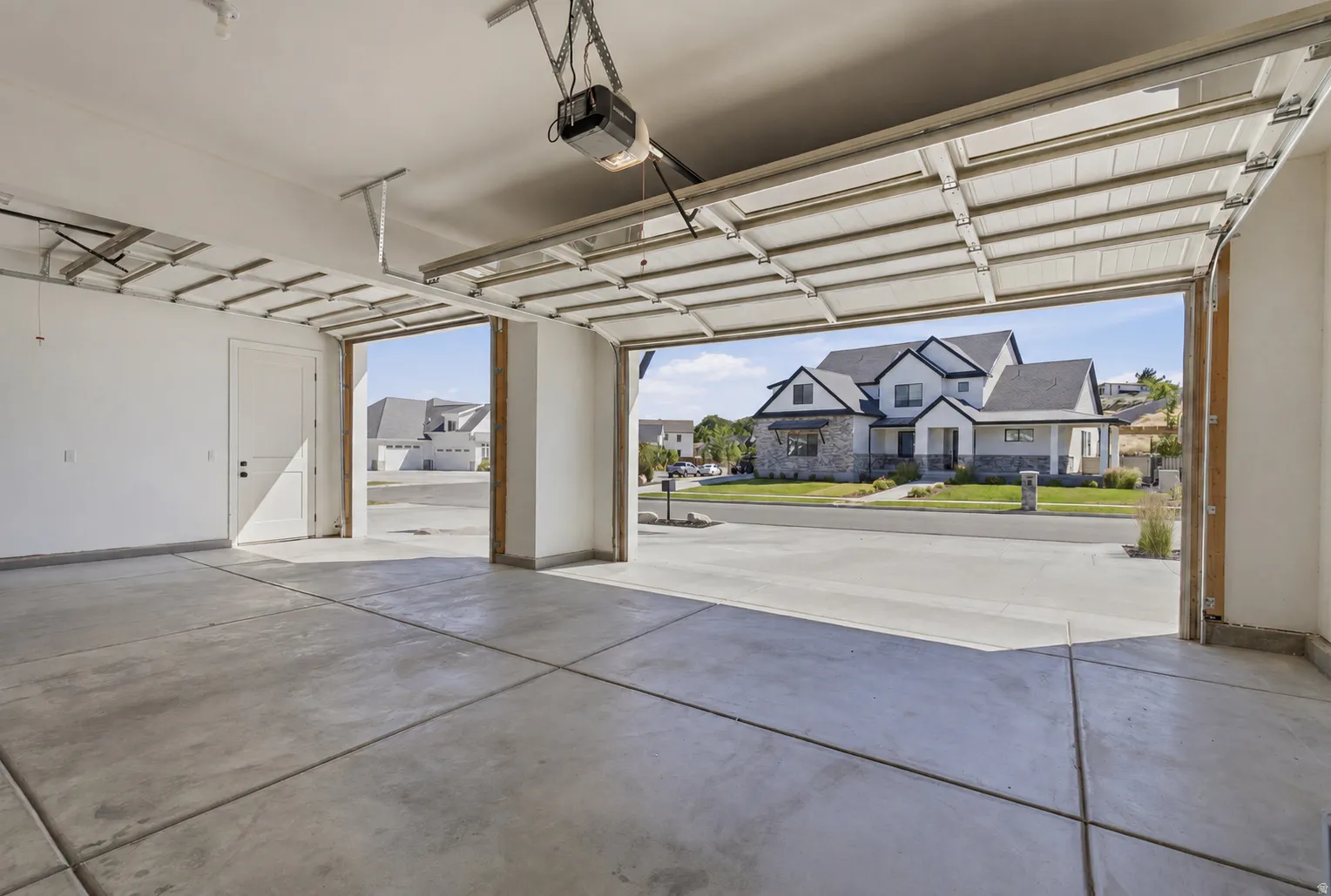 Spacious garage featuring concrete flooring and two garage door openers