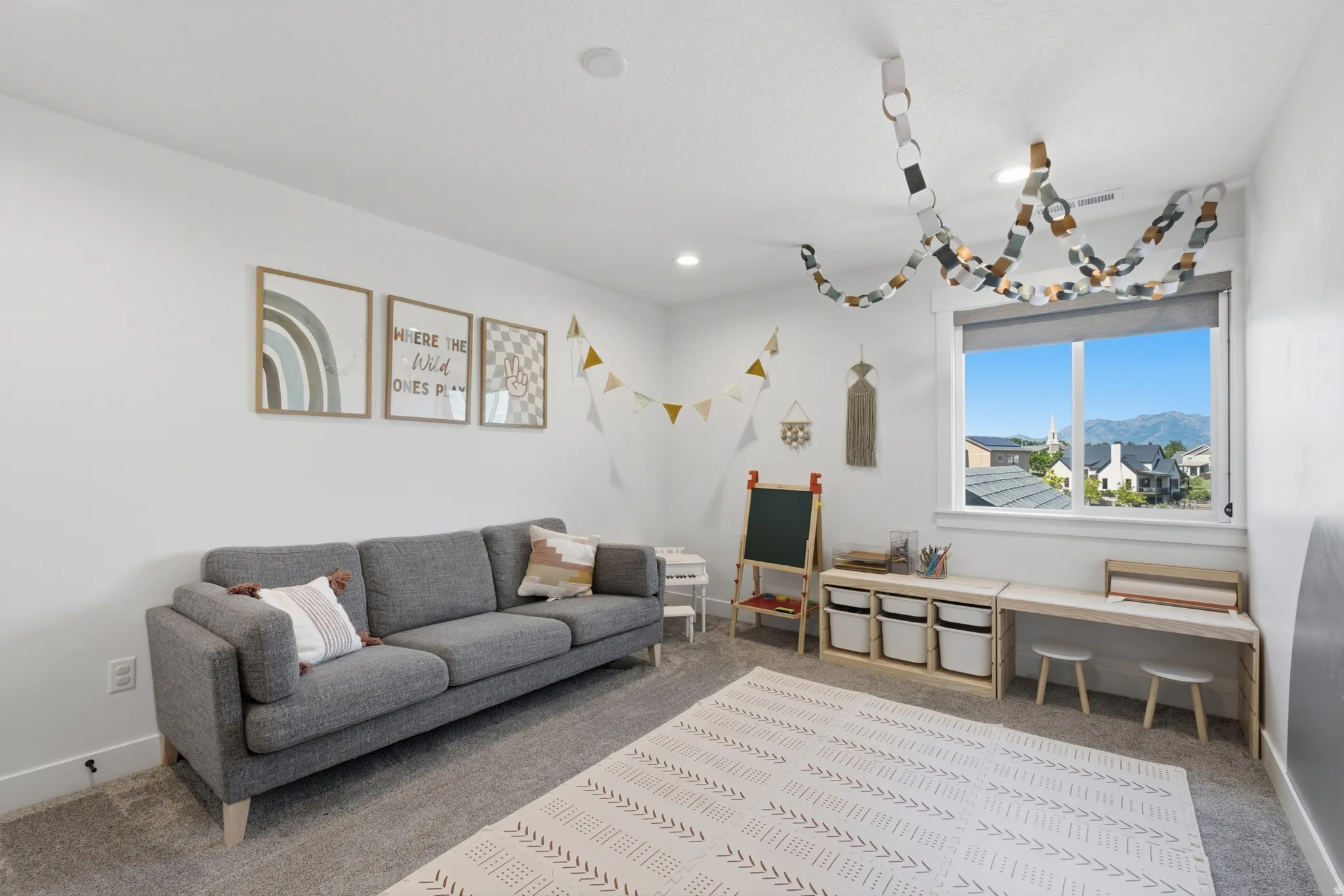 Bright room featuring white walls, recessed lighting, and a large window with roller shades