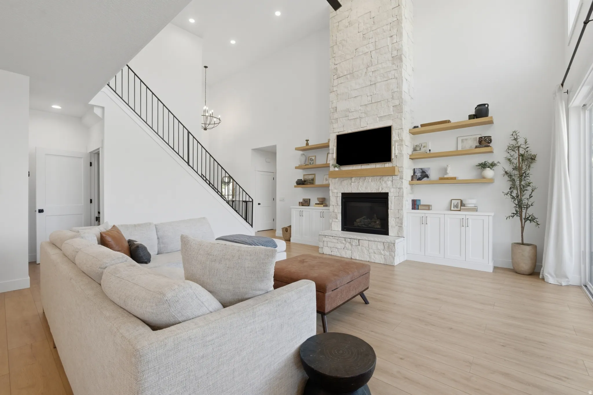 Living room with high ceilings and light wood-finish flooring