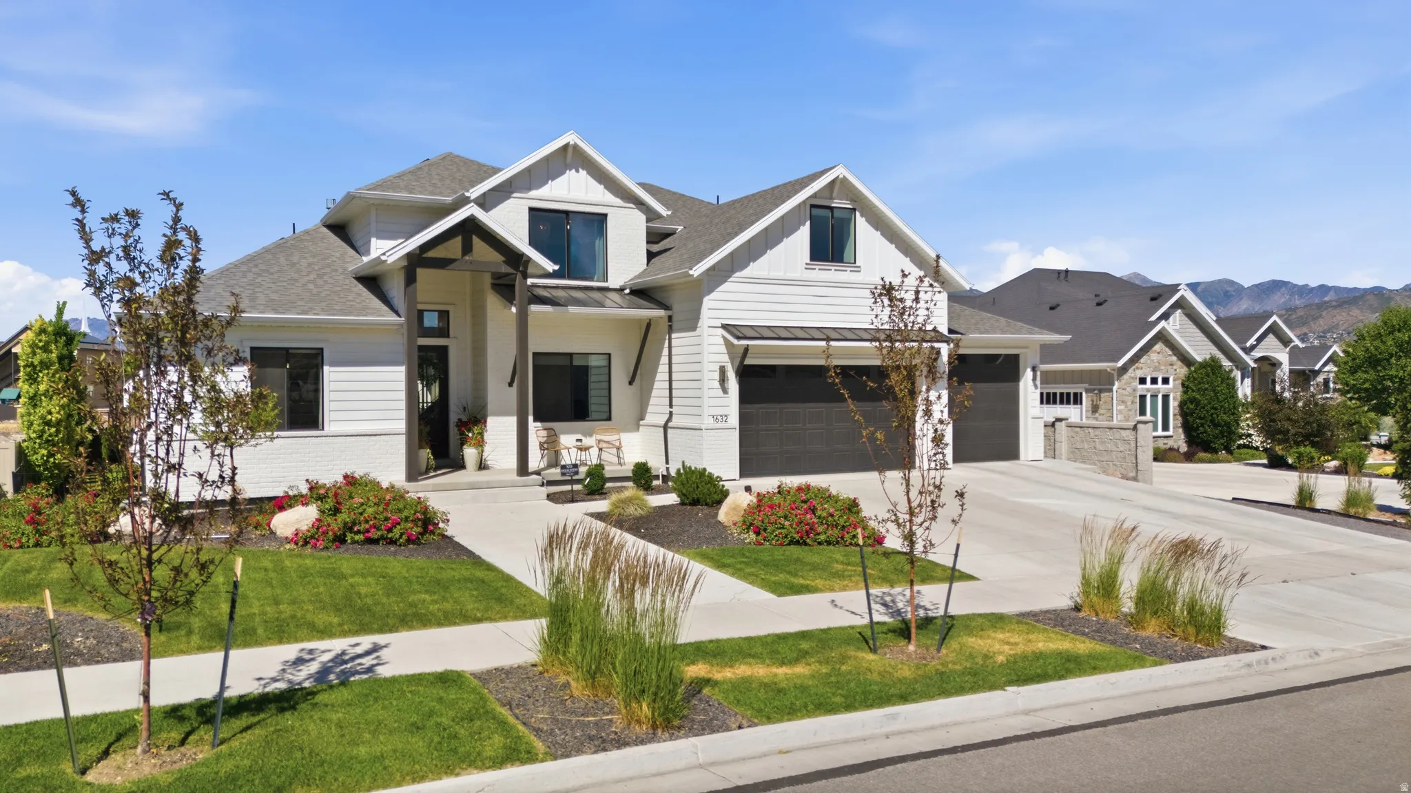 Contemporary residence featuring white siding and a dark roof