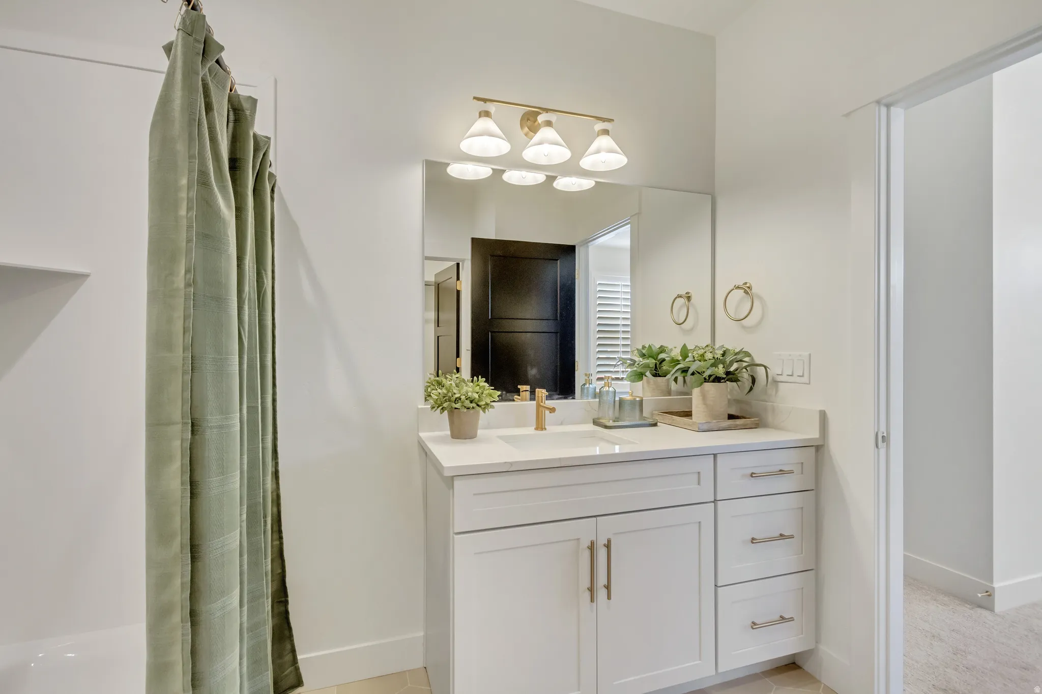 Bathroom vanity featuring a quartz countertop, integrated sink, and gold-finish faucet