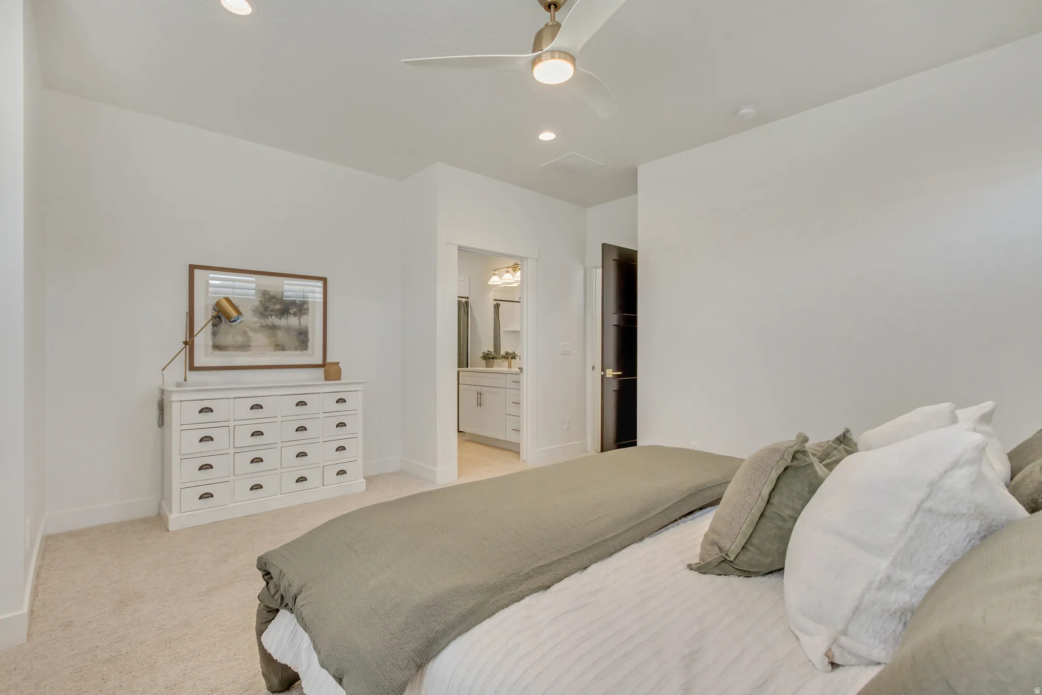 Bedroom featuring neutral carpeting, a ceiling fan with integrated lighting, recessed lighting, and a dark interior door