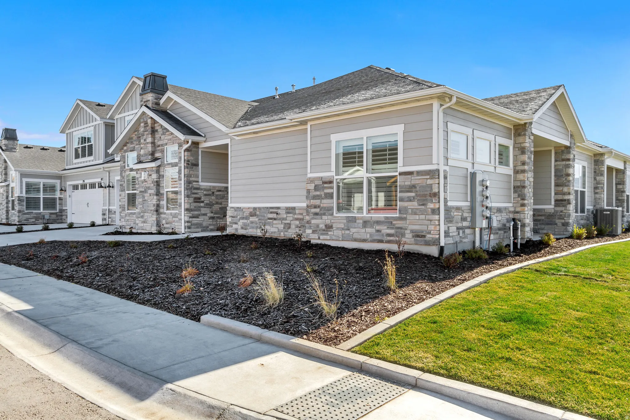 Modern architecture featuring light gray siding and natural stone veneer