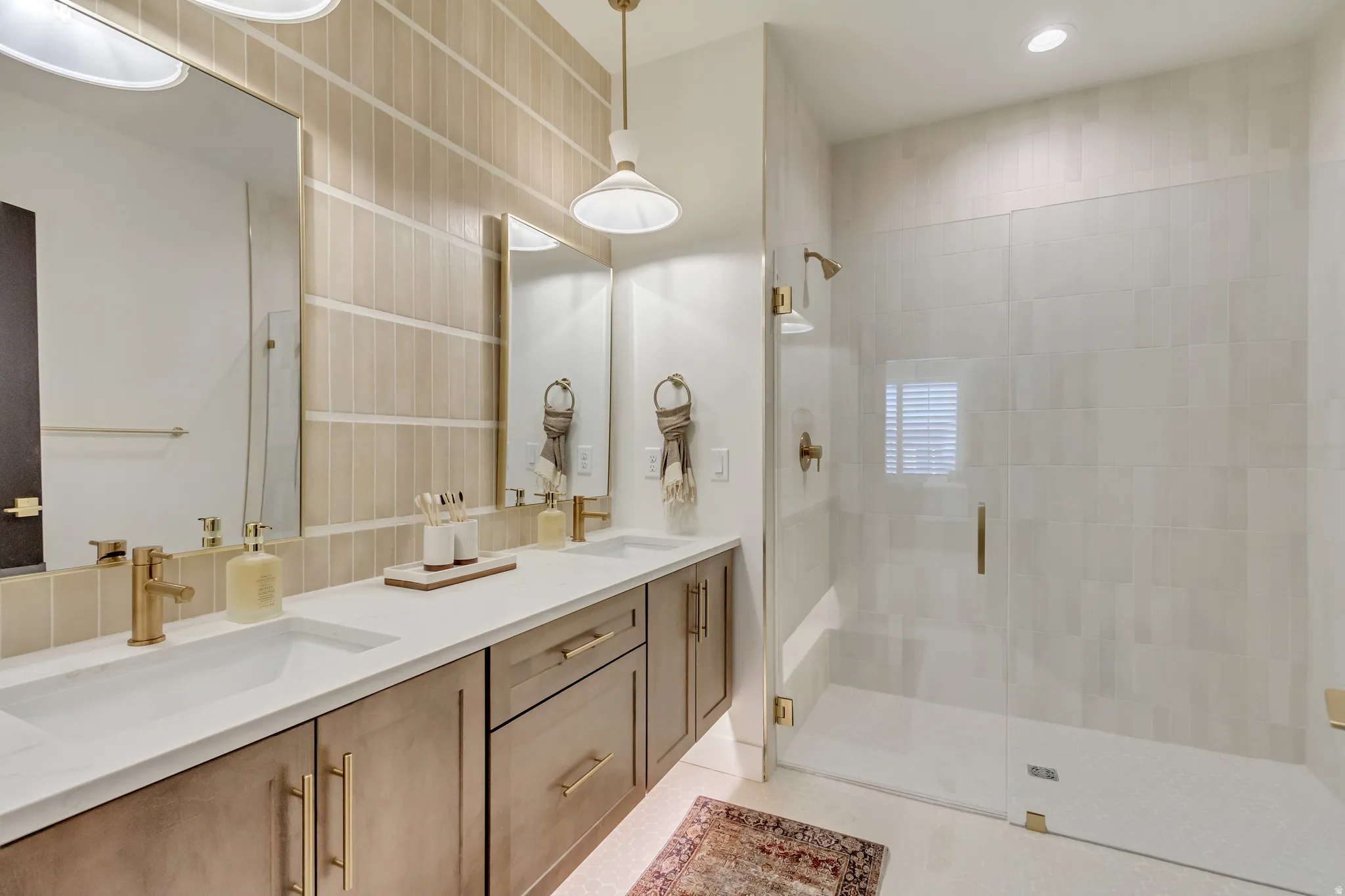 Dual vanity with white countertops, undermount sinks, and gold-finish fixtures