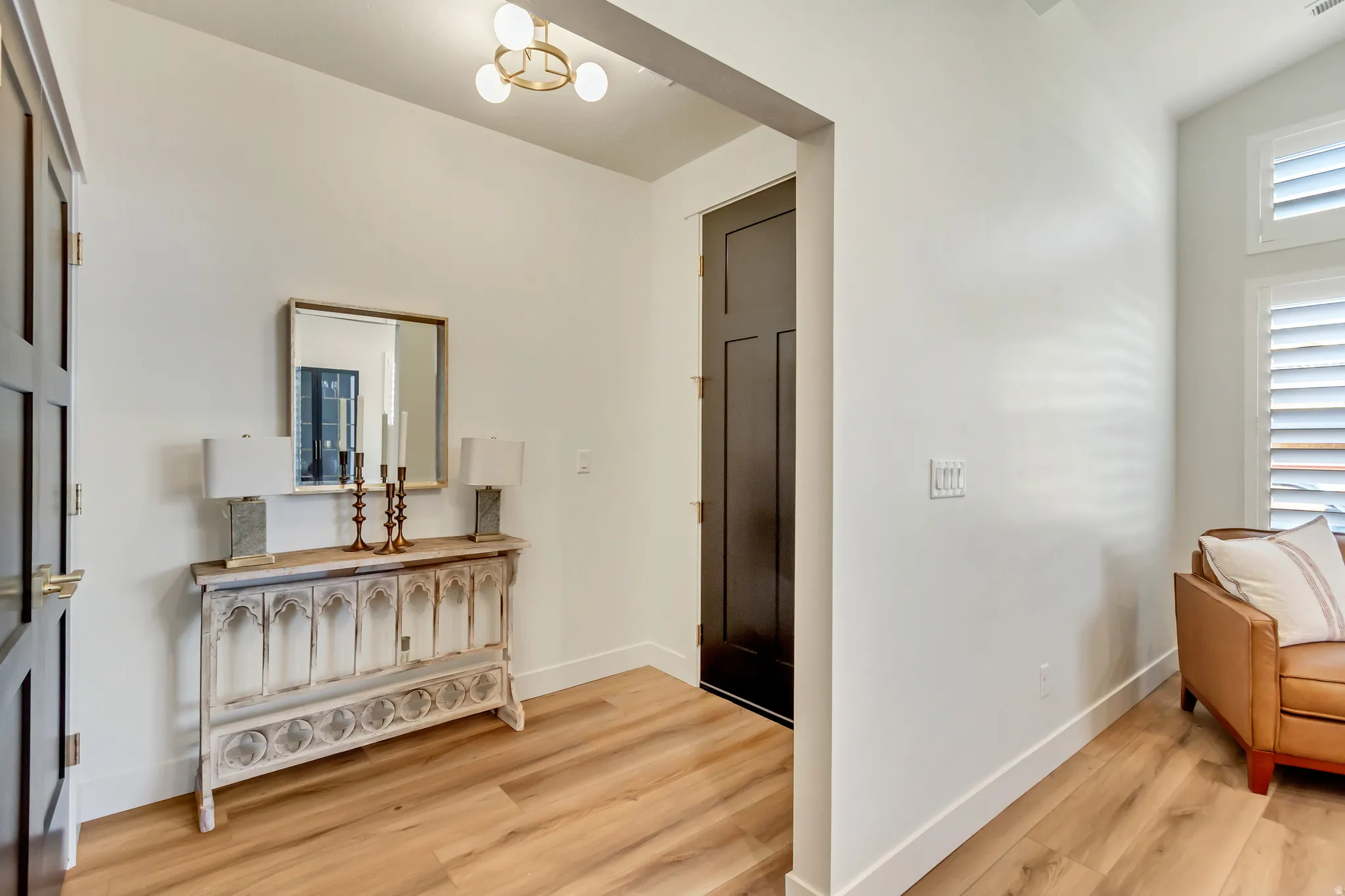 Entryway featuring wood-finish flooring, white walls, and a modern ceiling light fixture