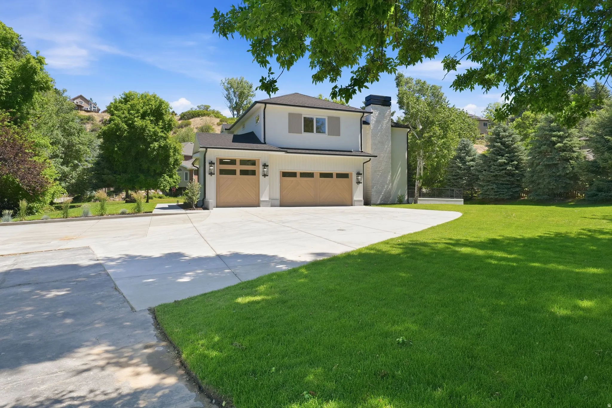 Contemporary exterior featuring a light-colored facade, dark trim, and a black shingle roof
