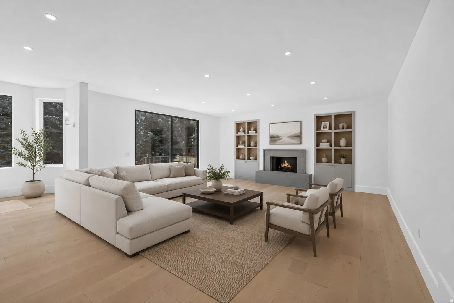 Virtually staged spacious living area featuring light wood-finish flooring, recessed lighting, and a modern fireplace with a substantial hearth
