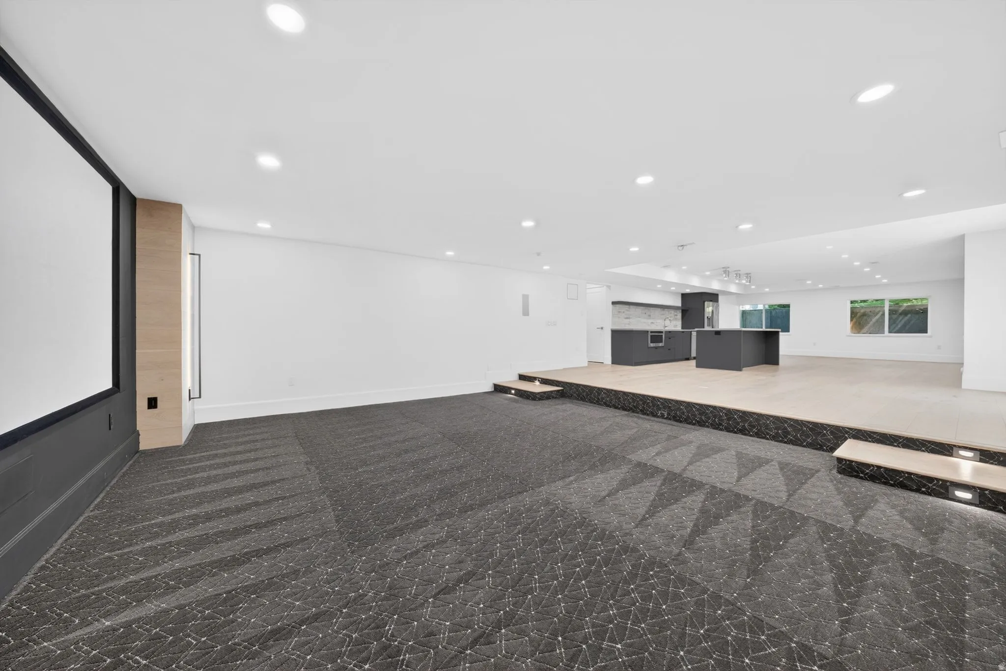 Theater room featuring a large projection screen, patterned carpet, wood-finish wall paneling, and recessed lighting