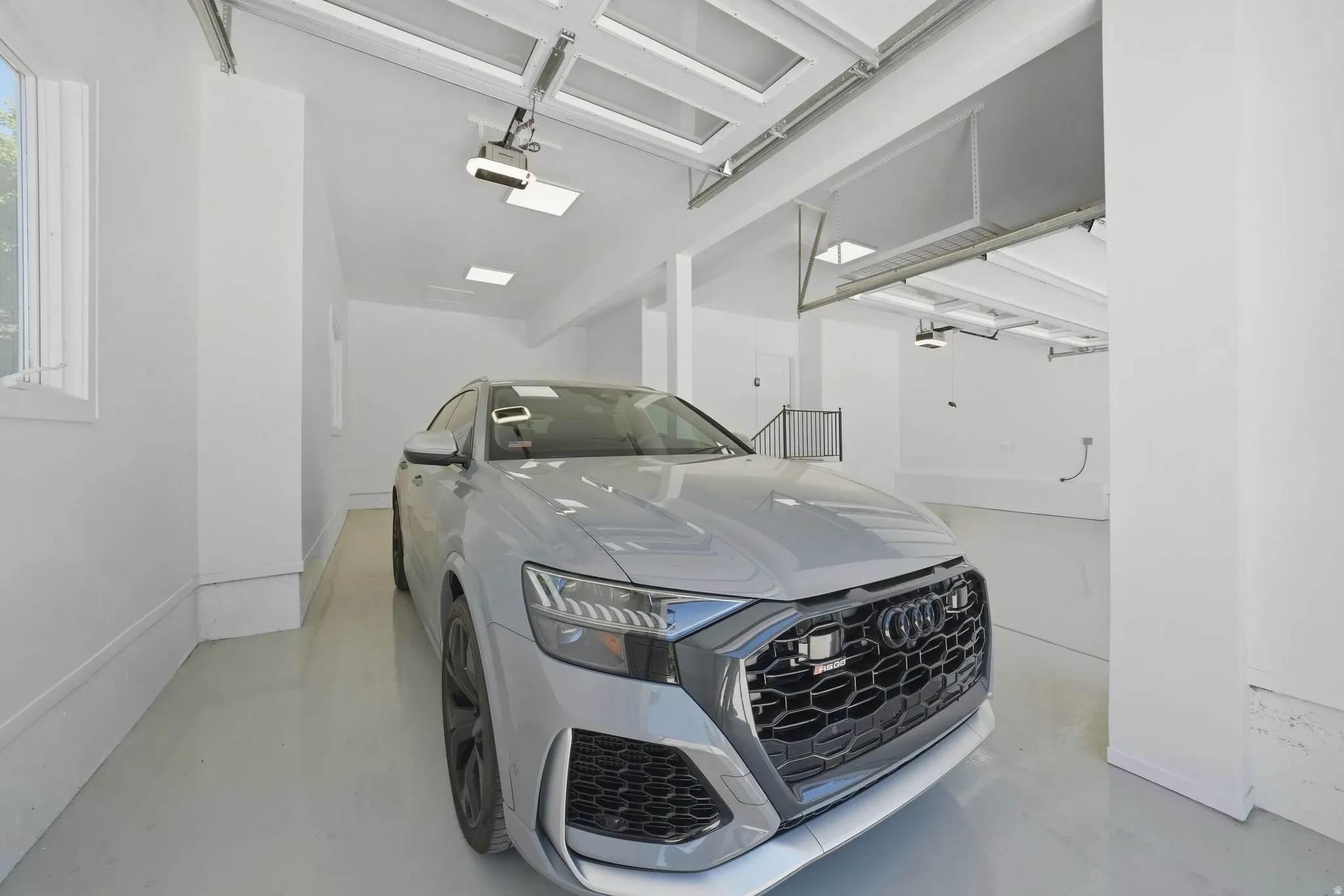 Spacious garage featuring light flooring, white walls, and an overhead garage door opener