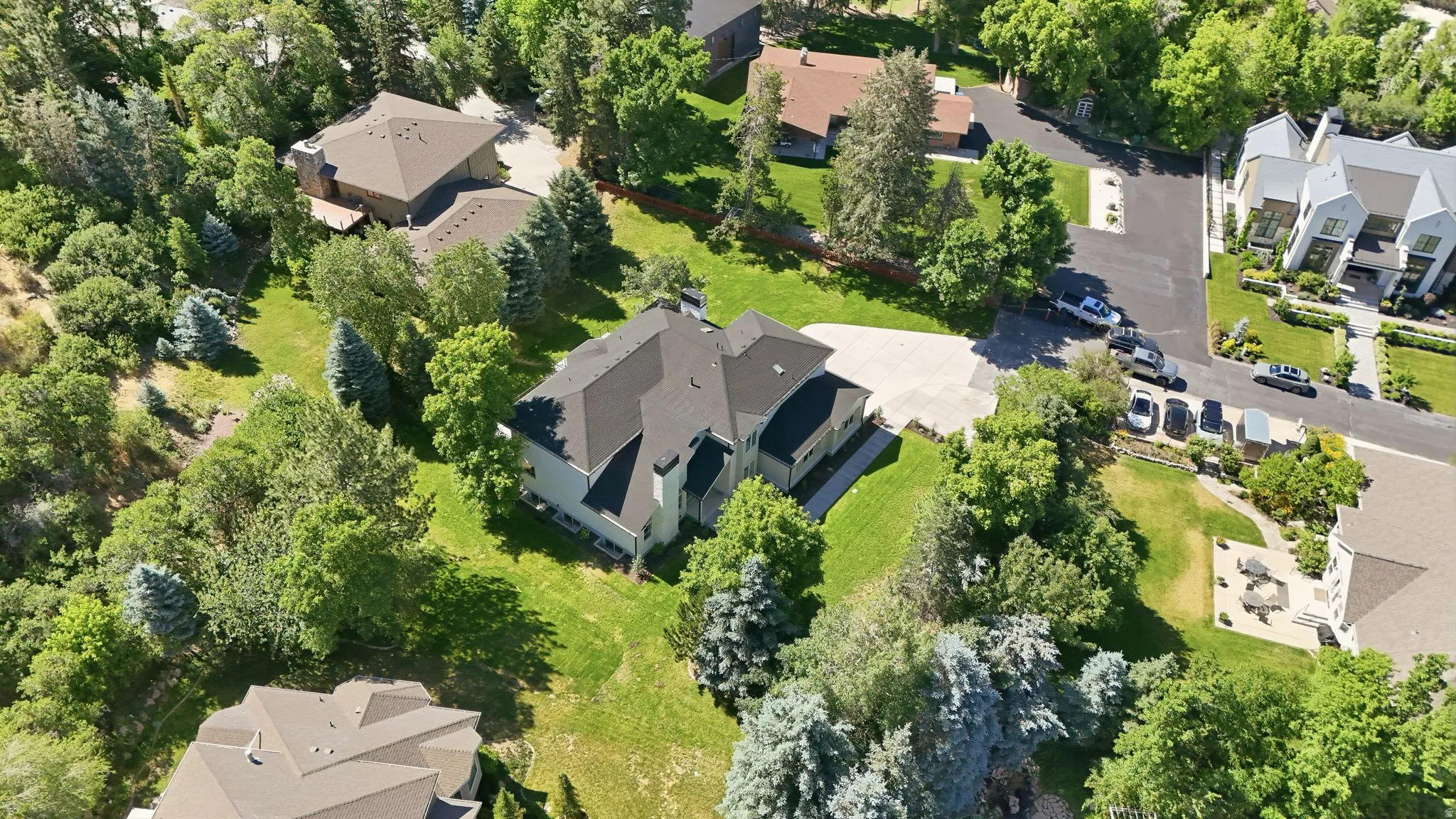 Two-story residence with a dark shingled roof, light-colored siding, and a prominent chimney
