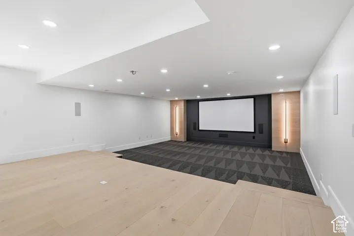 Dedicated theatre room with large projection screen, integrated speakers, and accent lighting