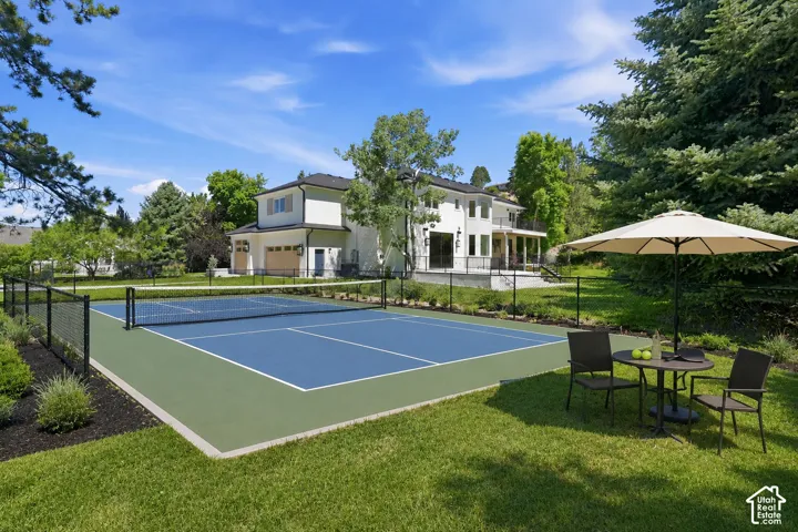 Virtually staged outdoor recreation area featuring a full-size tennis court with a black perimeter fence