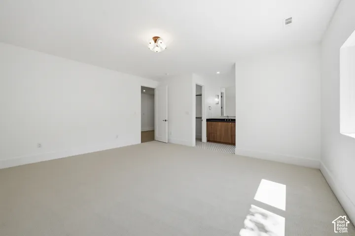 Third bedroom upstairs with Jack & Jill bathroom featuring light-colored carpeting and white walls