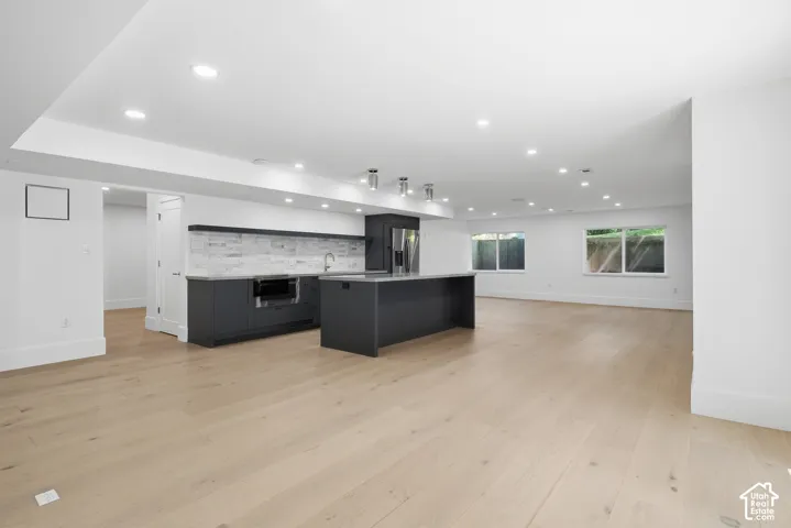 Downstairs spacious open-concept interior featuring light wood-finish flooring, separate entrance, and recessed lighting