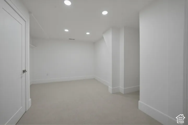 Downstairs bedroom with recessed lighting, white walls, and white trim