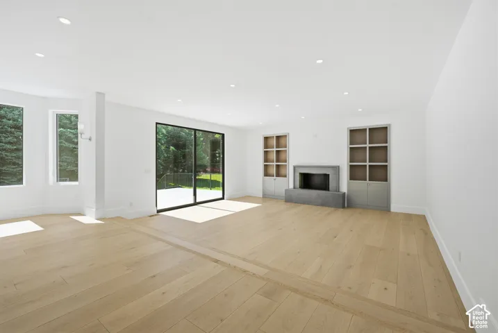 Spacious room with light wood-finish flooring featuring a decorative inlay