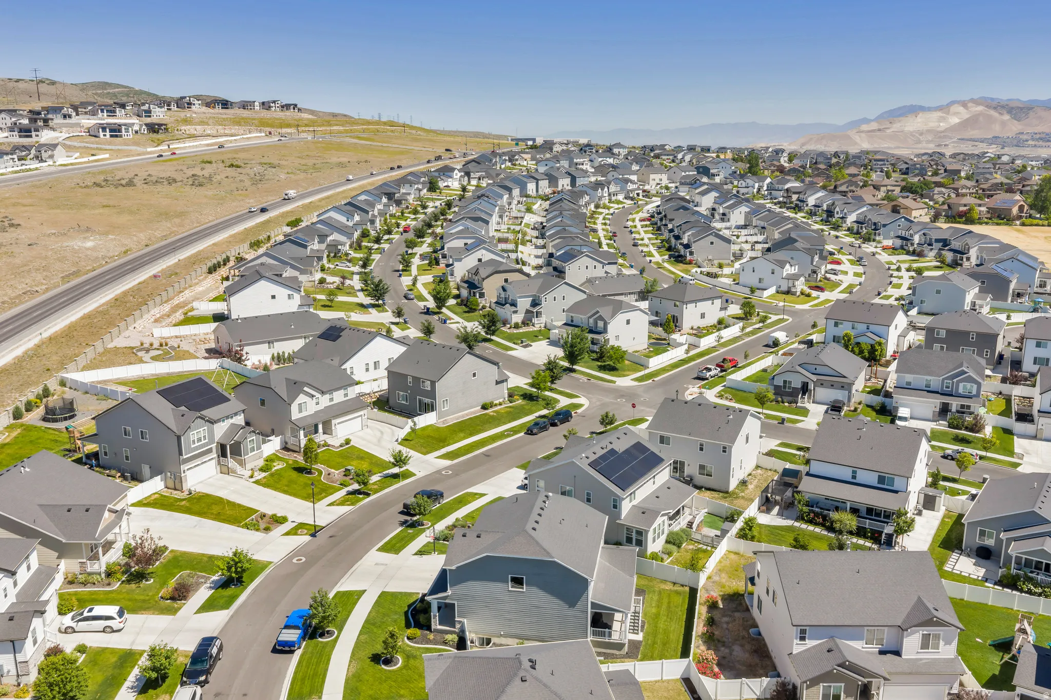 Modern residential development featuring numerous single-family homes with gray roofs and varied exterior finishes