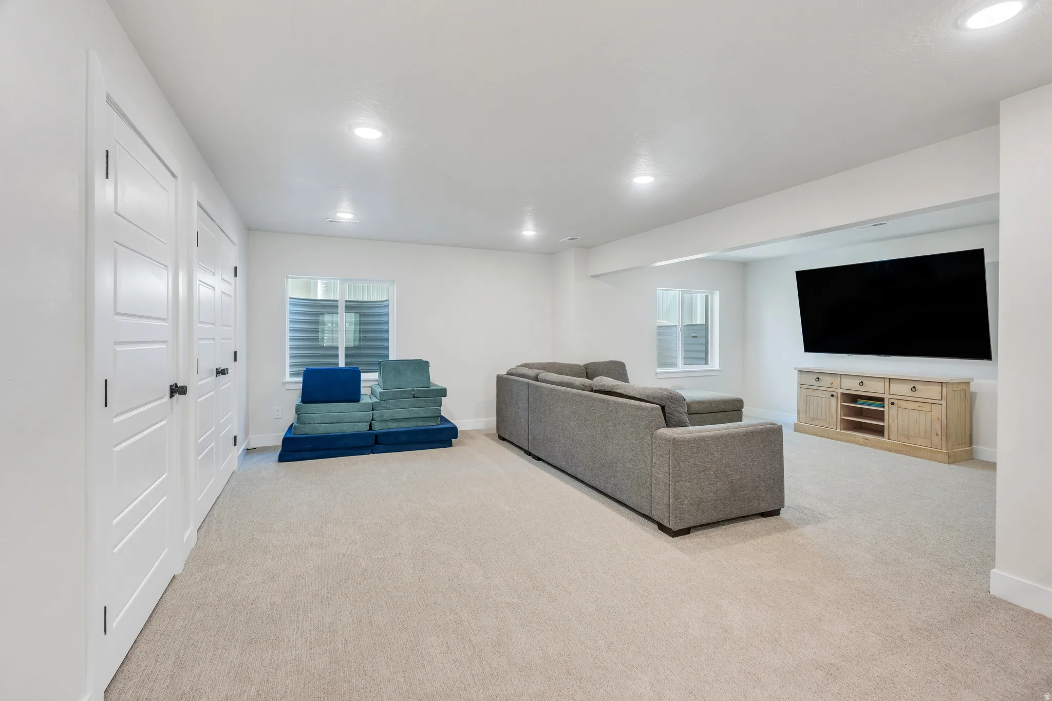 Spacious room featuring light carpeting and recessed lighting