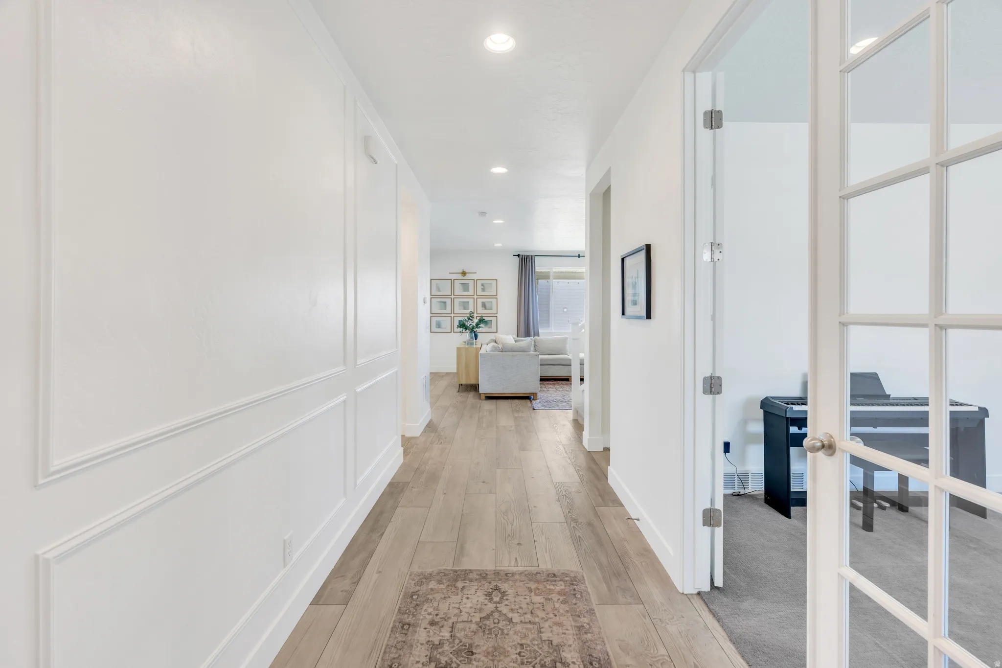 Entryway corridor featuring wood-finish flooring, recessed lighting, and decorative wall molding