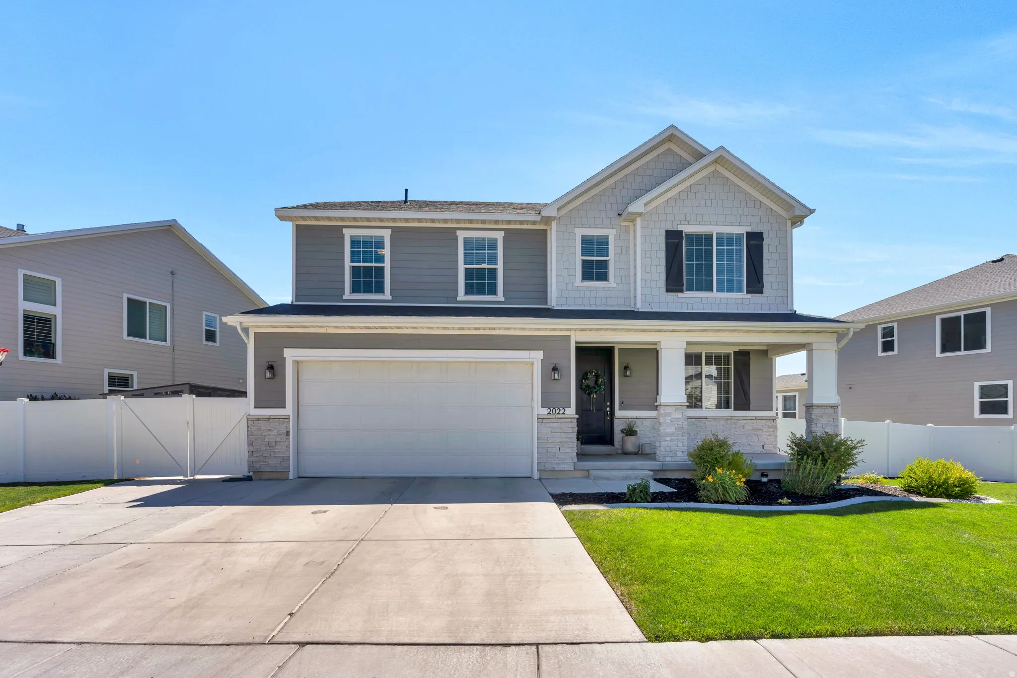 Two-story residence featuring a two-car garage, covered porch, and layered siding