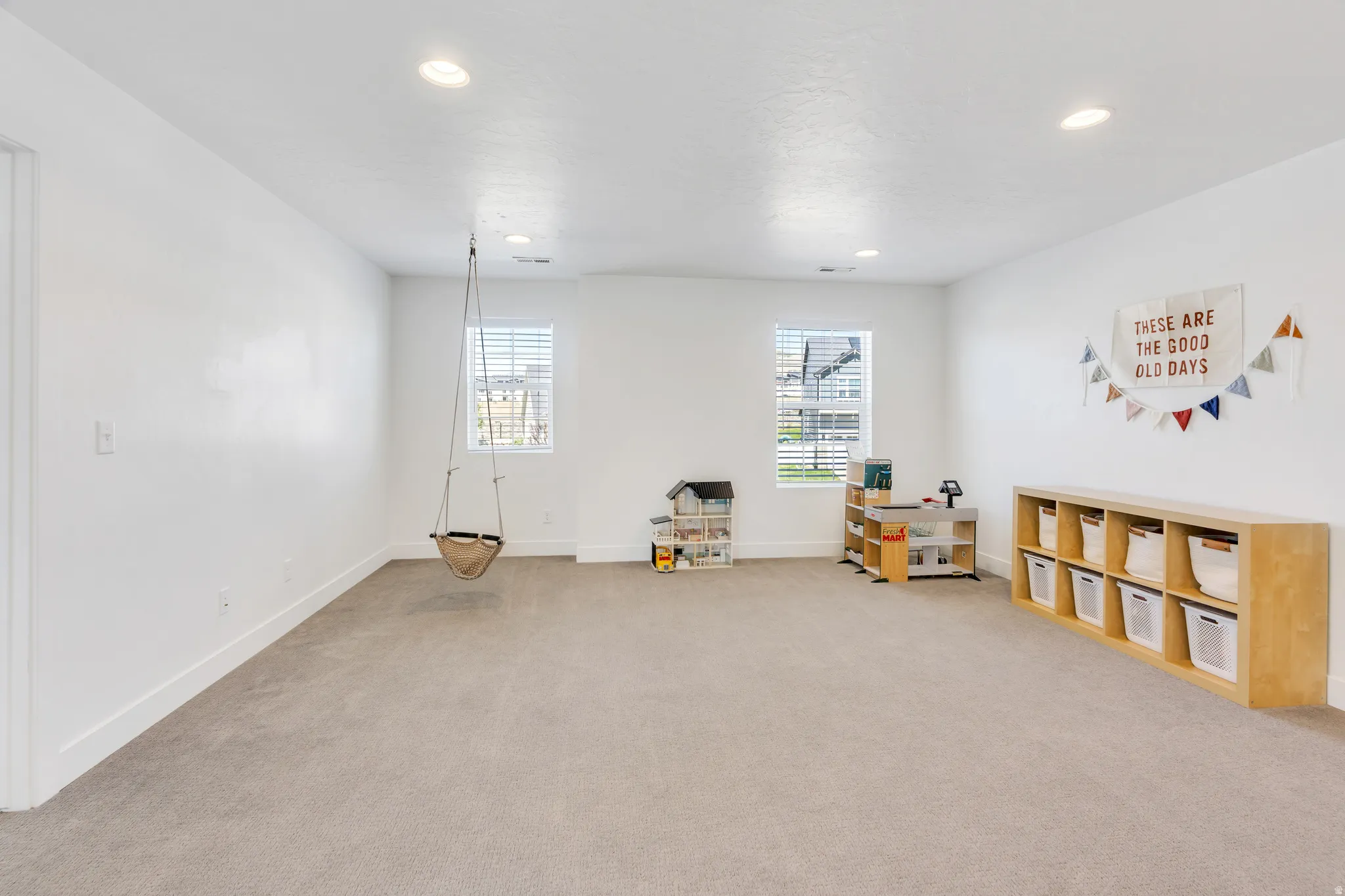 Spacious room featuring neutral carpet flooring, white walls, and recessed lighting