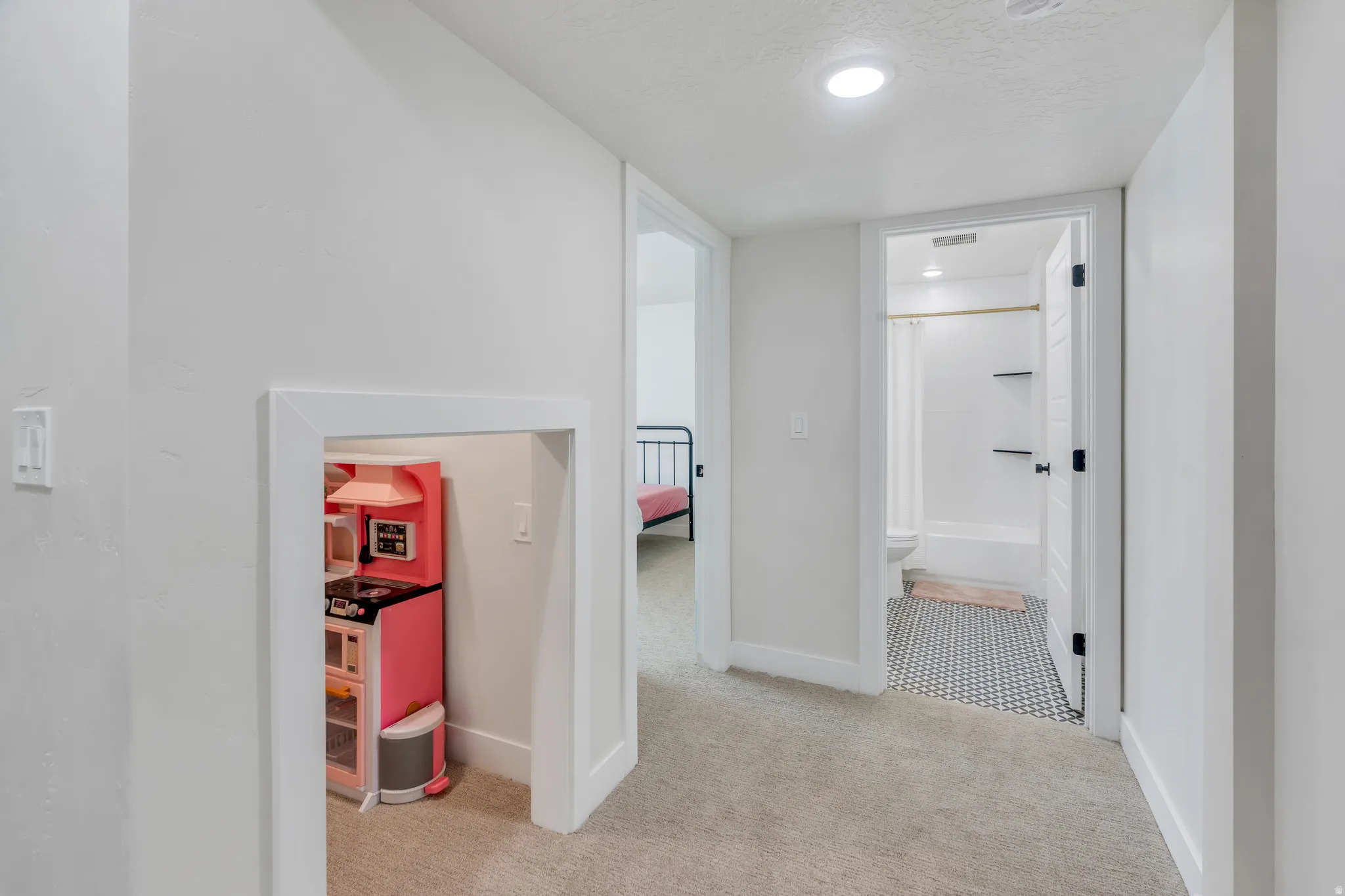 Hallway featuring carpet flooring, crisp white walls, recessed lighting, and a built-in play nook