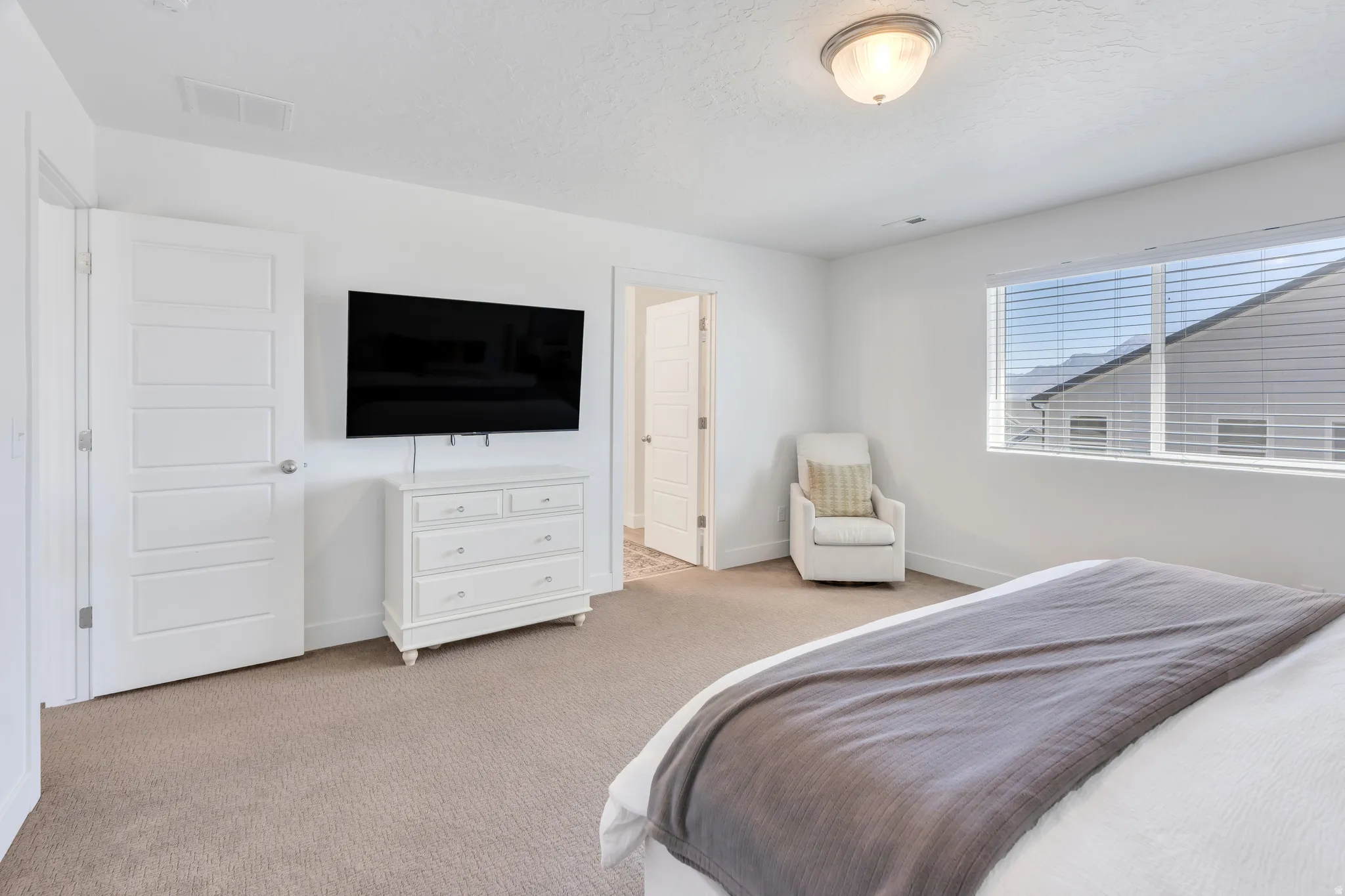 Neutral-toned carpet flooring and white walls define this space