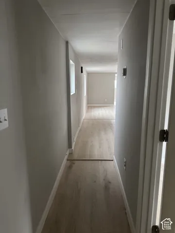 Neutral wall finish featuring light-toned wood-finish flooring and recessed square windows