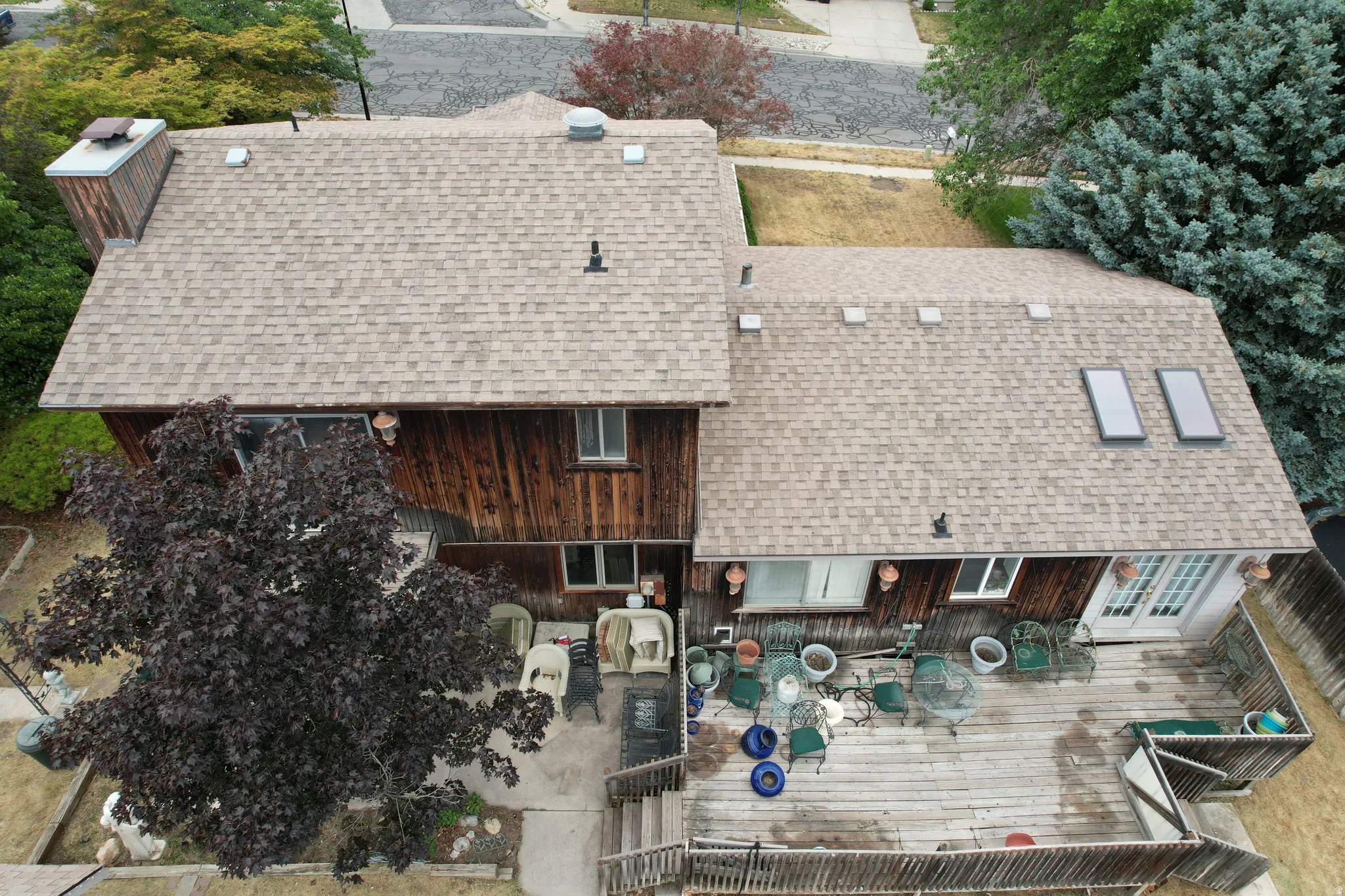 Shingled roofline with multiple skylights and a large exterior chimney