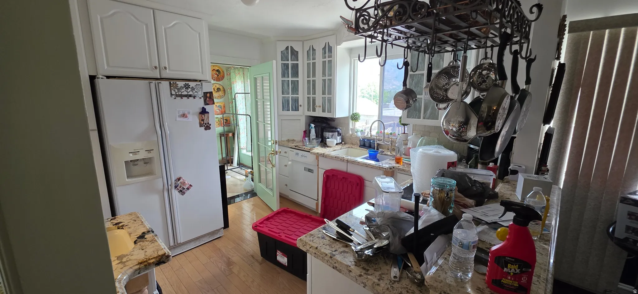Kitchen featuring wood-finish flooring, white cabinetry, granite countertops, and a double-door refrigerator
