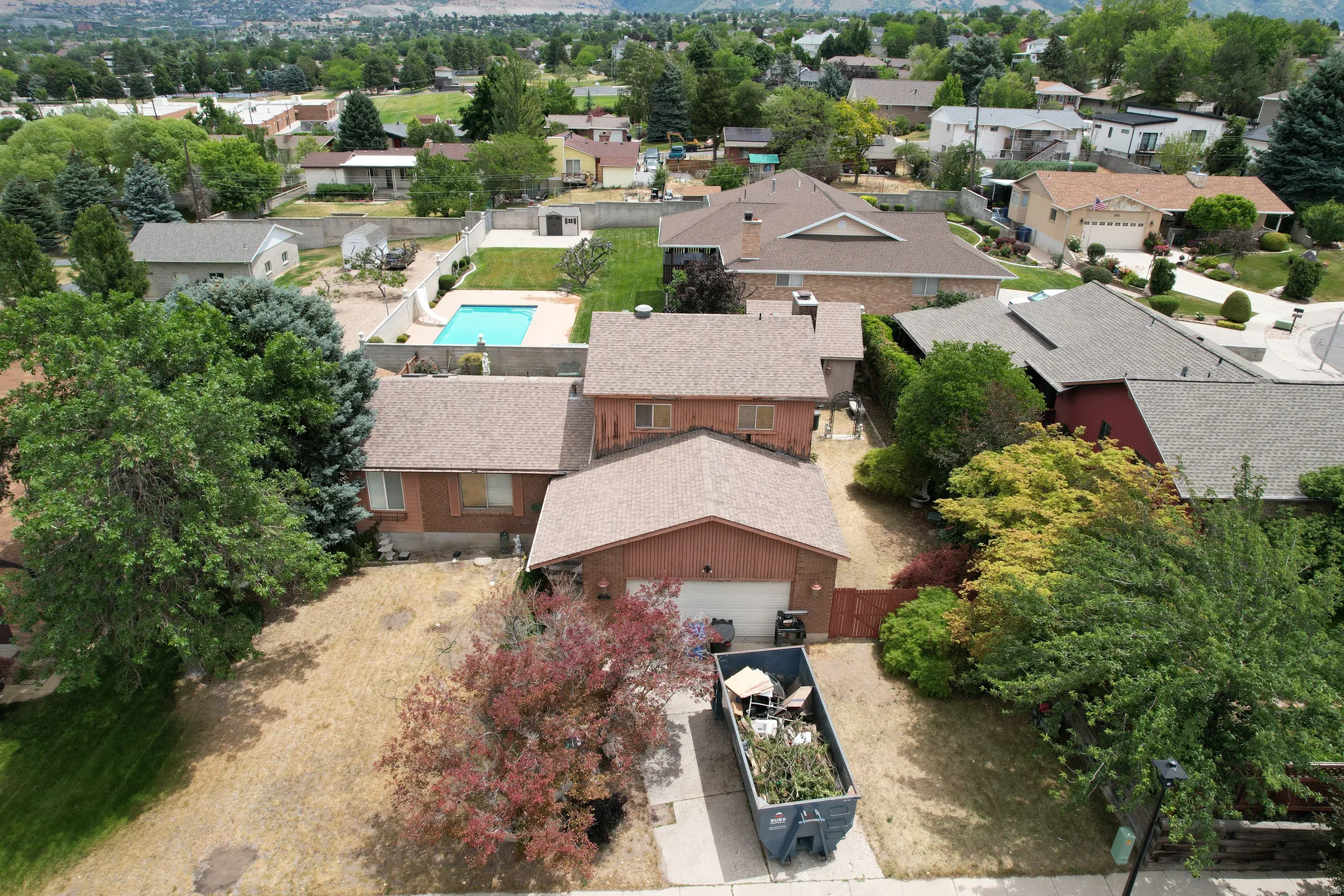 Property featuring a brown-toned exterior, an attached garage, and a concrete driveway